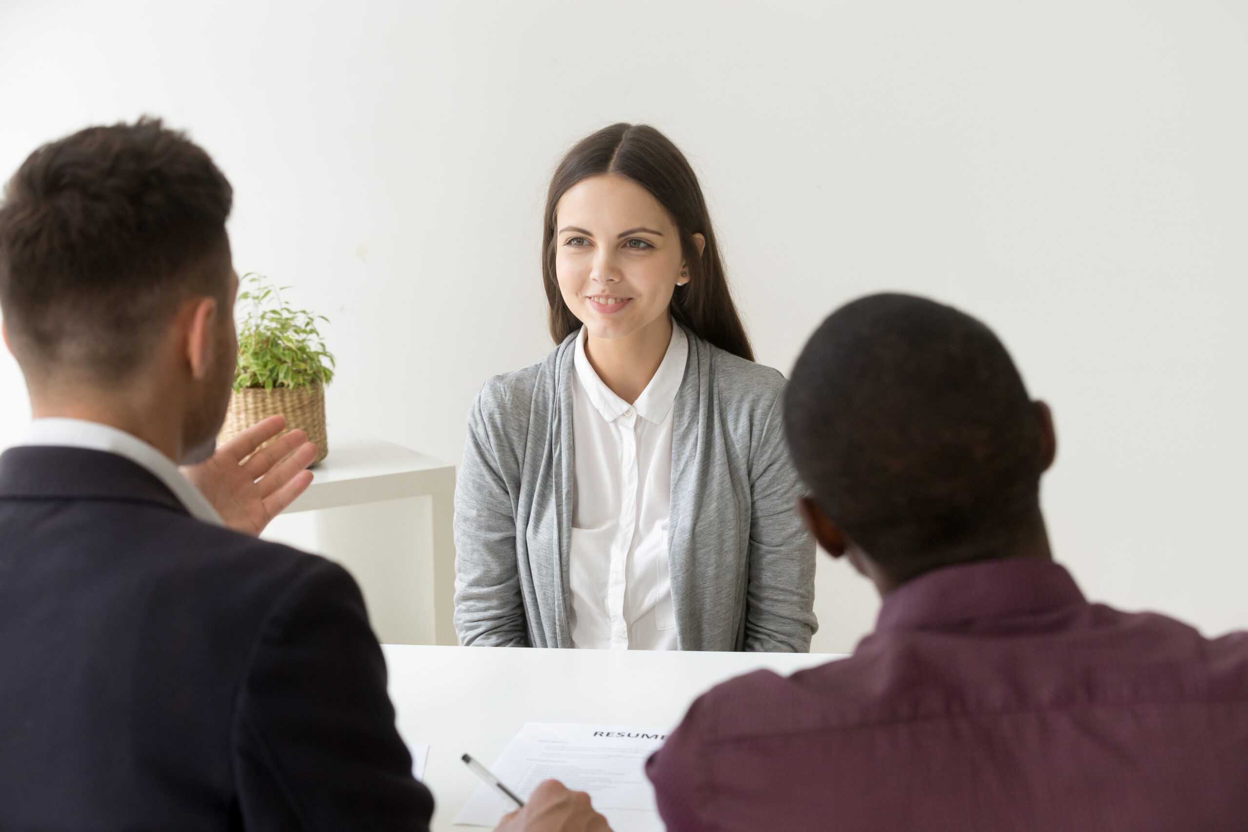 Confident female applicant smiling at job interview with diverse hr managers, young happy professional candidate talks to multiracial recruiters makes good first impression, employment hiring concept