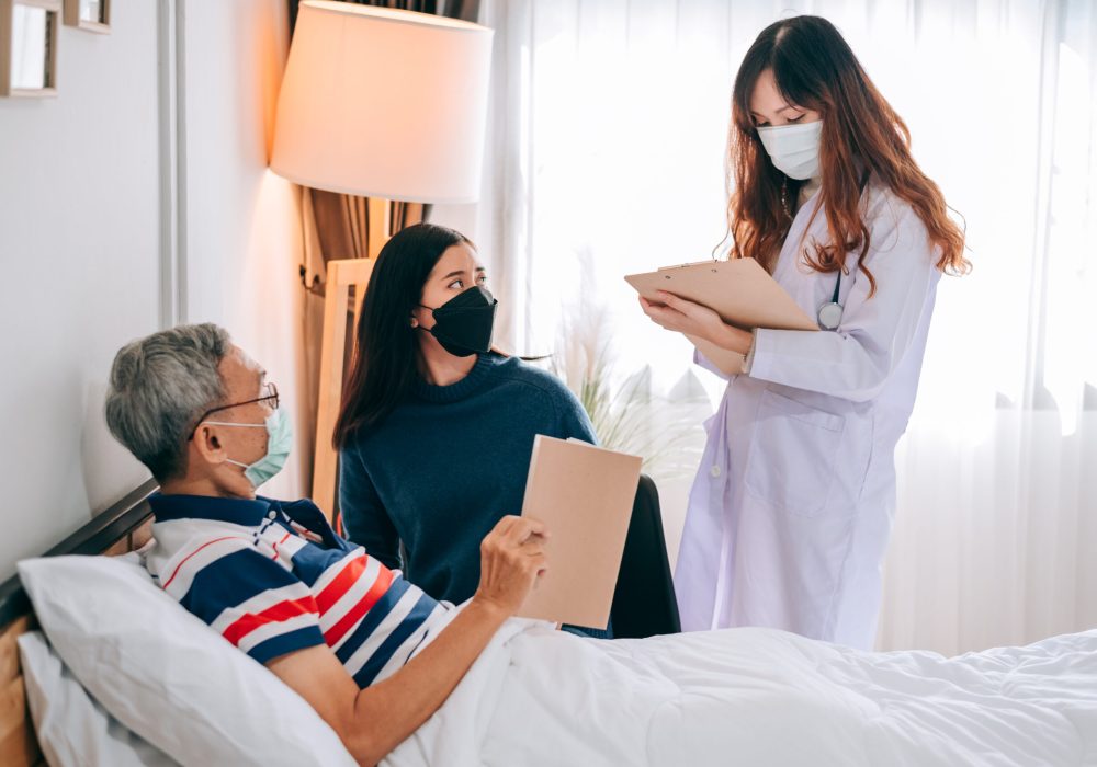 Asian doctor visit and examines a senior man at home ,The doctor checking up and consulting for retirement health partient,hospital services ,and wearing a mask to protect covid-19.