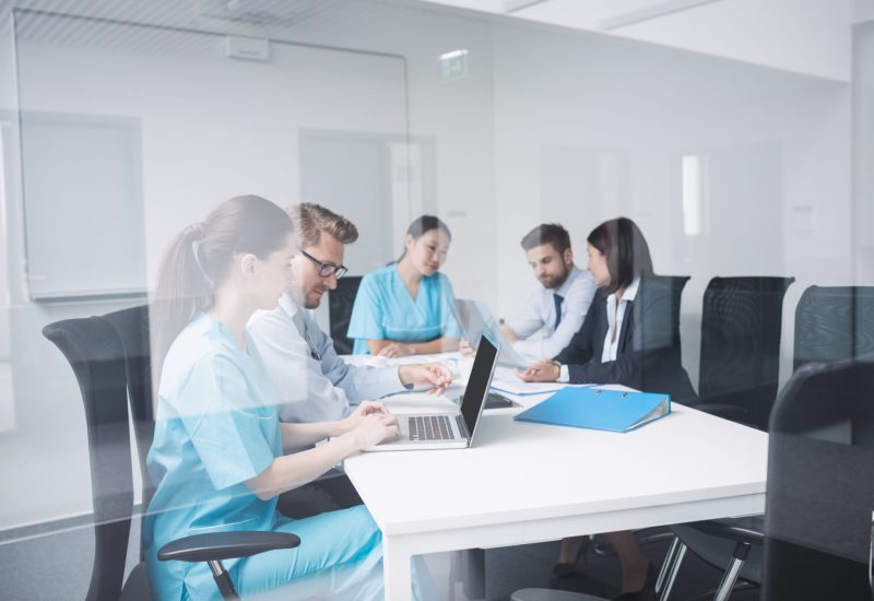 Doctors discussing over laptop in meeting at conference room