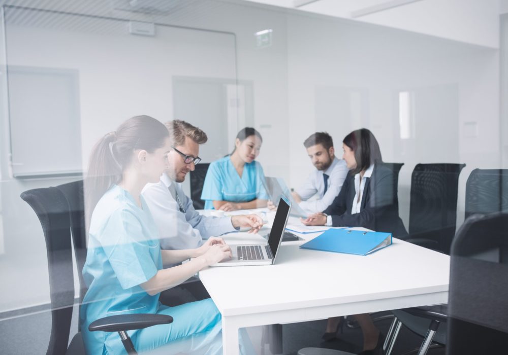 Doctors discussing over laptop in meeting at conference room