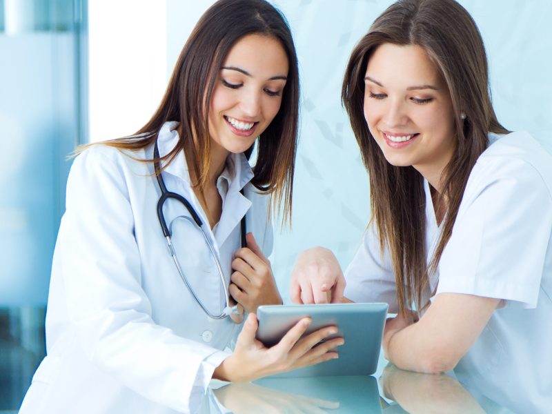 medical and nurse looking for something on a digital tablet at the hospital