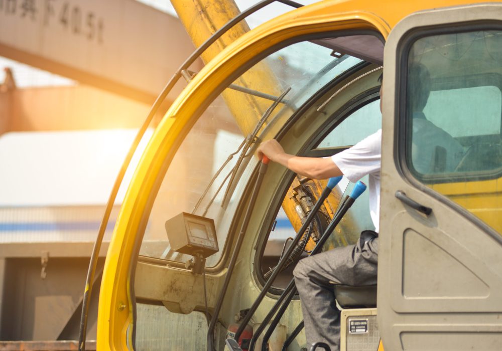 Man driving a crane to lift-up some equipments